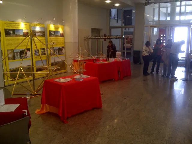 Messestand mit rot gedeckten Tischen, auf denen Horus Energiepyramiden-Modelle ausgestellt sind, dahinter gelbe Infotafeln mit Bildern und Text im Foyer des Vaduzersaals.