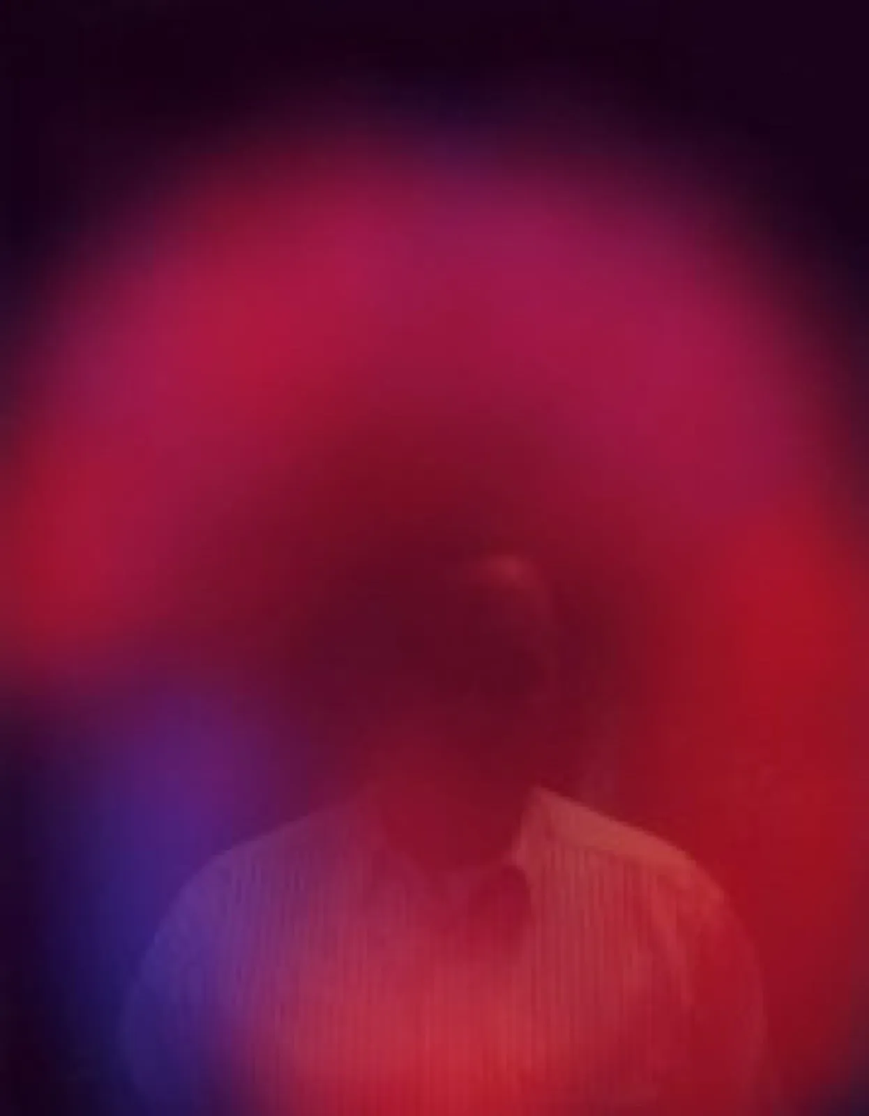 Aurafoto von 1997: Oberkörperporträt eines Mannes in hellem Hemd, fast vollständig von einem kräftig roten bis magentafarbenen Lichtschleier überdeckt, links unten ein blauer Farbbereich.