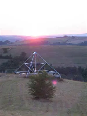 Die 9-Meter-Energiepyramide bei Sonnenuntergang mit einem kleinen roten Lichtreflex