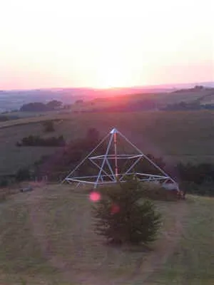 Die 9-Meter-Energiepyramide im Gegenlicht der untergehenden Sonne mit rotem Lichtreflex
