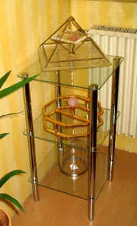 Glas-Etagere mit Energiepyramide Modell A oben und einer Kupferspule (Schwingkreis) mit Rosenquarz darunter