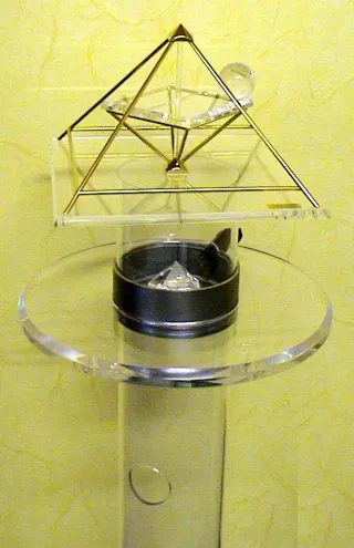 Energiepyramide Modell A auf einer Acrylsäule mit einem Horus-Ring (Stahlband) um das Rohr