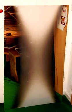 Ein hoher Spiegel an der Wand mit einer ungewöhnlichen, nebligen Doppelkegel-Erscheinung in der Mitte
