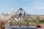 Energiepyramide Modell B im Freien auf einer Terrasse mit blühendem Baum und kleinen Figuren auf der mittleren Ebene