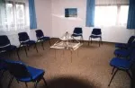 Stuhlkreis in einem Seminarraum um eine Energiepyramide Modell B auf einem Glastisch
