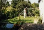 Energiepyramide Modell C in einem naturnahen Garten neben einem Haus