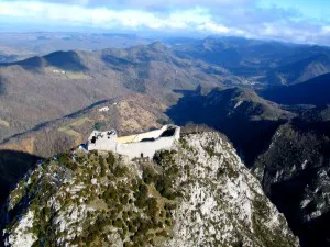 Luftbild der Burgruine Montségur auf einem steilen Felsgipfel in den Pyrenäen – die letzte Bastion der Katharer.