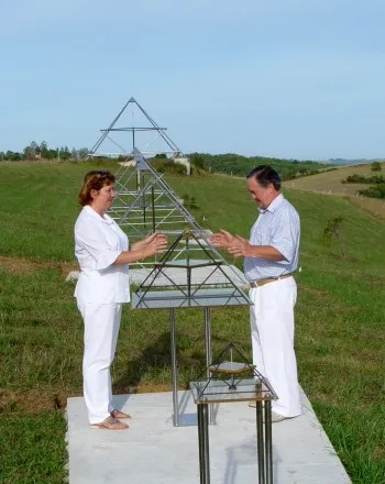 Verena und D. Harald Alke in weißer Kleidung an einer Horus-Energiepyramide auf dem Feld von Le Braquet