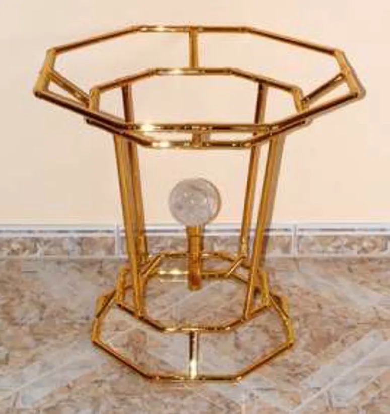 Der Horus-Brunnen von der Seite: ein goldener, achteckiger Rahmen aus mehreren Bagua-Ringen mit einer Bergkristallkugel im Zentrum, auf gefliestem Boden