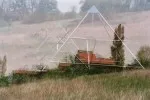 Verschwommene, neblige Aufnahme einer Energiepyramide mit Bank auf einem Feld