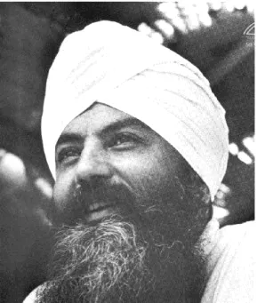 Schwarz-weiß-Porträt von Yogi Bhajan, einem bärtigen Mann mit weißem Turban, der lächelnd nach oben blickt