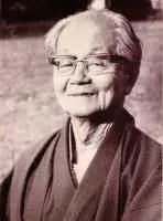 Sepia-Porträt von Roshi Tetsuo Nagaya, einem älteren ostasiatischen Mann mit Brille und dunkler Zen-Robe