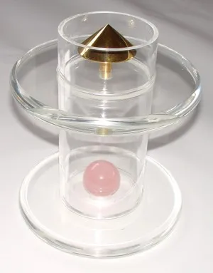 Goldener Energiekegel auf einem Acrylhalter, darunter eine Rosenquarzkugel